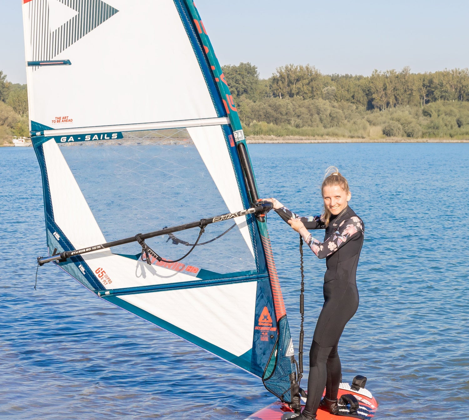 Blonde Frau auf einem roten Surfboard.