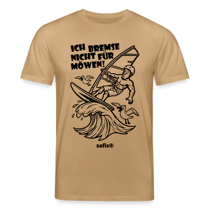 Schwarzer print vorn auf einem karamellfarbenen safis® T-Shirt aus Bio-Baumwolle mit der Aufschrift 'ICH BREMSE NICHT FÜR MÖWEN!'. Die Cartoon-Grafik zeigt einen Windsurfer mit Helm auf einer Welle, umringt von fliegenden Möwen. -Möwe- Unisex Bio-T-Shirt CREATOR - Karamell 