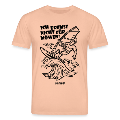Schwarzer print vorn auf einem pfirsichfarbenen safis® T-Shirt aus Bio-Baumwolle mit der Aufschrift 'ICH BREMSE NICHT FÜR MÖWEN!'. Die Cartoon-Grafik zeigt einen Windsurfer mit Helm auf einer Welle, umringt von fliegenden Möwen. -Möwe- Unisex Bio-T-Shirt CREATOR - Pfirsich