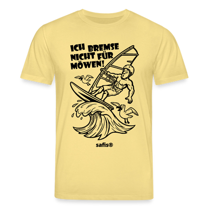 Schwarzer print vorn auf einem hellgelben safis® T-Shirt aus Bio-Baumwolle mit der Aufschrift 'ICH BREMSE NICHT FÜR MÖWEN!'. Die Cartoon-Grafik zeigt einen Windsurfer mit Helm auf einer Welle, umringt von fliegenden Möwen. -Möwe- Unisex Bio-T-Shirt CREATOR - Gelb Viva 